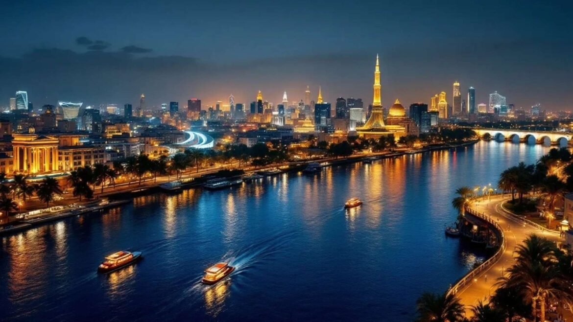 Illuminated skyline of Cairo at night with boats sailing on the Nile River