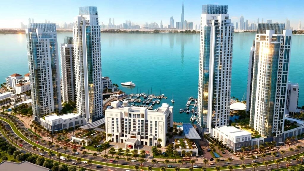 Aerial view of modern high-rise towers and marina at Dubai Creek Harbour with Burj Khalifa skyline in the background