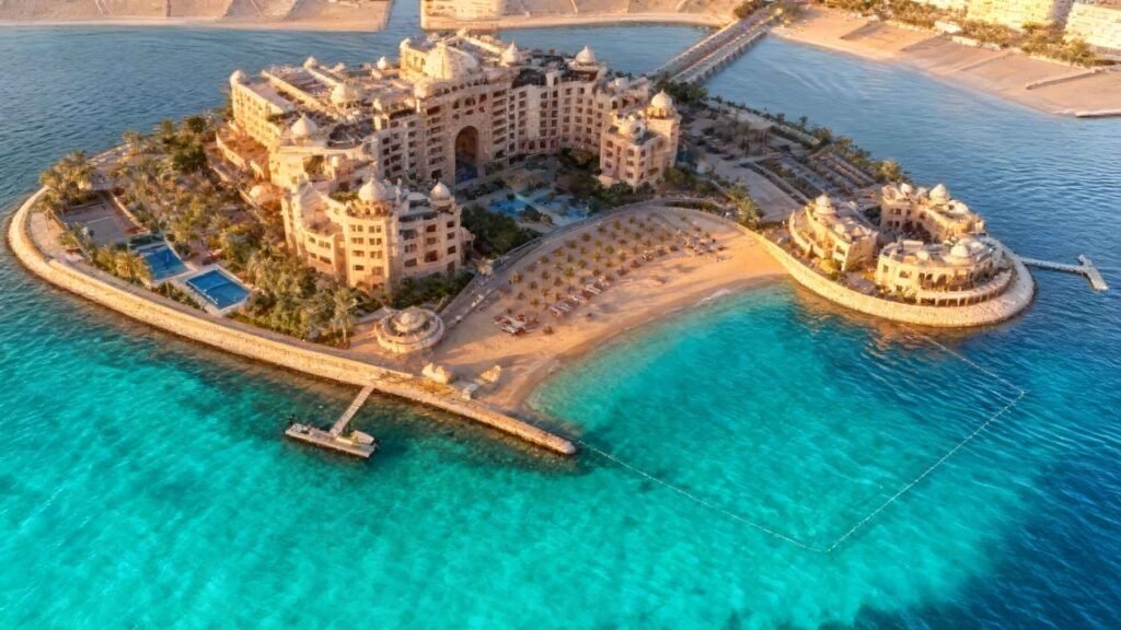 “Skyline view of Doha showing modern towers in West Bay for Qatar real estate investment.”waters, golden sand, palm trees, and island-style architecture during golden hour.