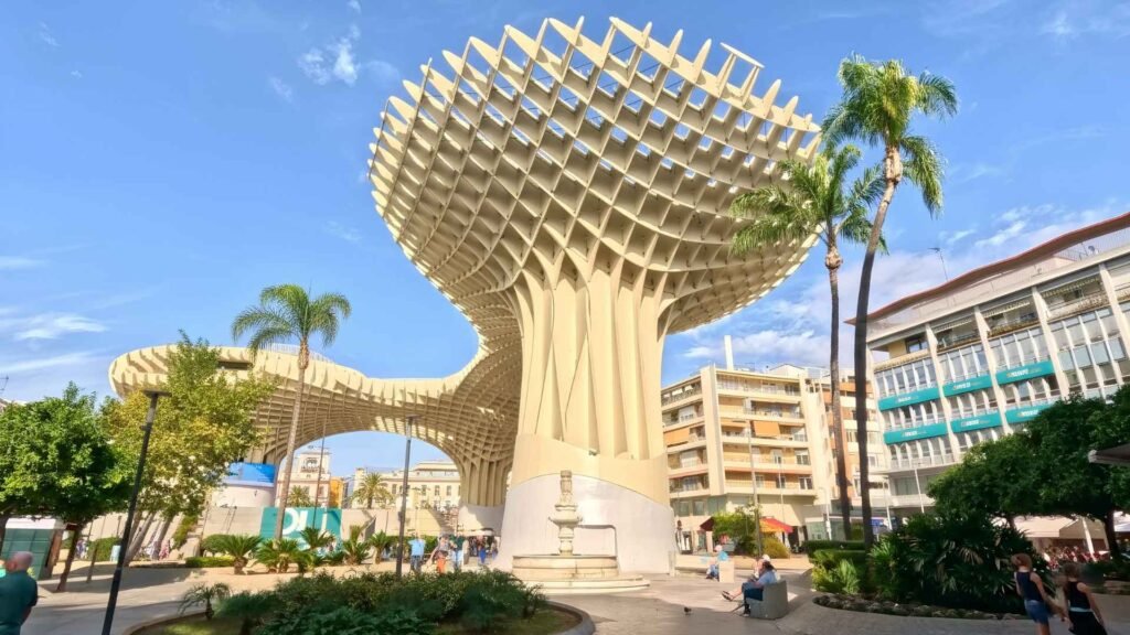 Metropol Parasol in Seville, Spain, photographed on a sunny day with a clear open foreground, no poles or obstacles, surrounded by palm trees and modern buildings.