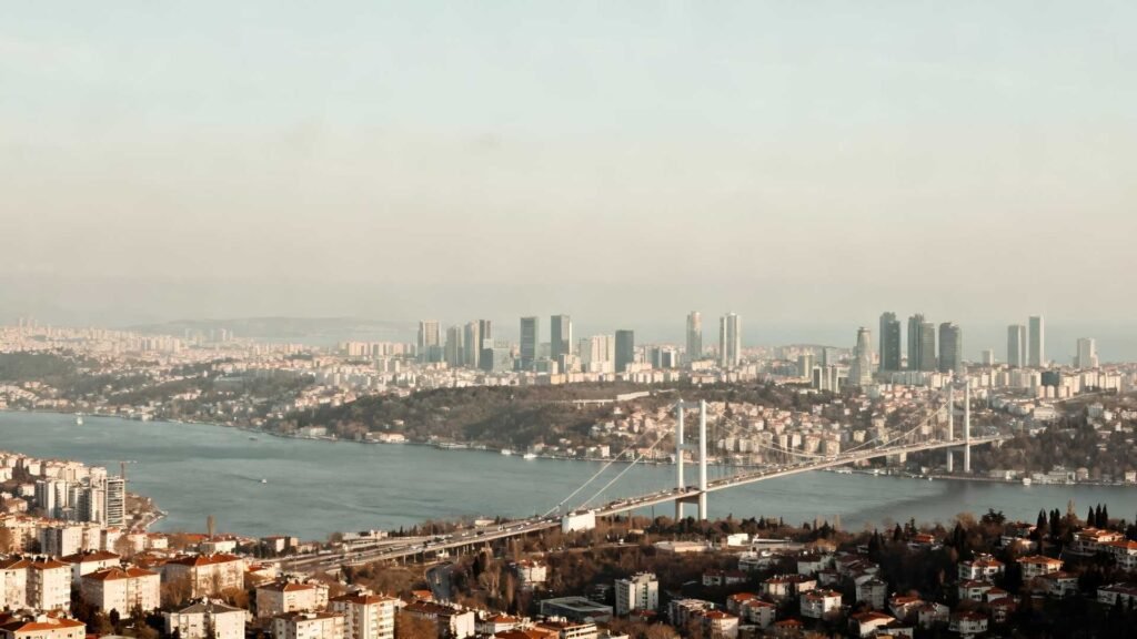 Panoramic view of the Bosphorus Bridge with Istanbul skyline, waterfront neighborhoods, and modern skyscrapers
