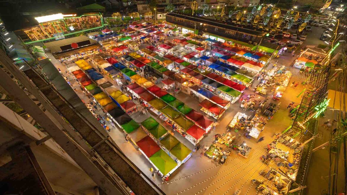 Chatuchak Weekend Market in Bangkok with crowded walkways, street food stalls, and vibrant evening atmosphere