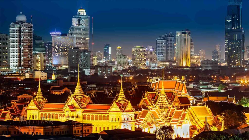 The Grand Palace illuminated at night in Bangkok, showcasing Thailand’s royal architecture
