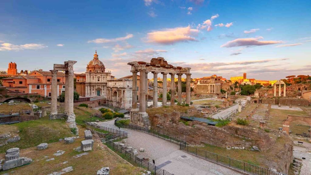 Roman Forum in Rome at sunset with ancient ruins glowing under warm golden light and a dramatic evening sky