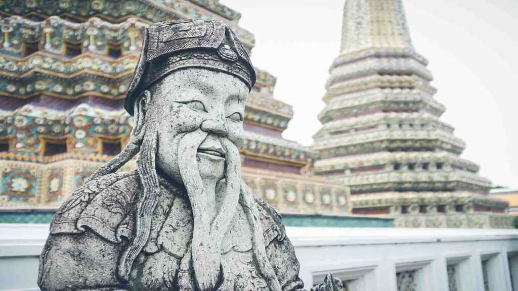 Stone guardian statue located in the garden of Wat Arun Temple in Bangkok, reflecting Thai spiritual symbolism and temple artistry
