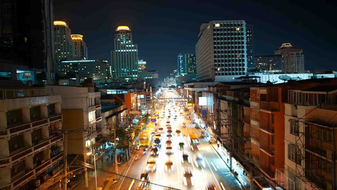 Silom Nightlife - City highway traffic with illuminated skyscrapers in Bangkok at night, Thailand