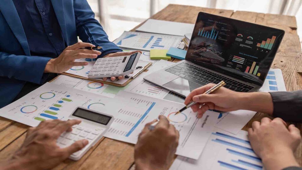 Confident business people analyzing market data, graphs, and balance sheet charts during a strategic meeting