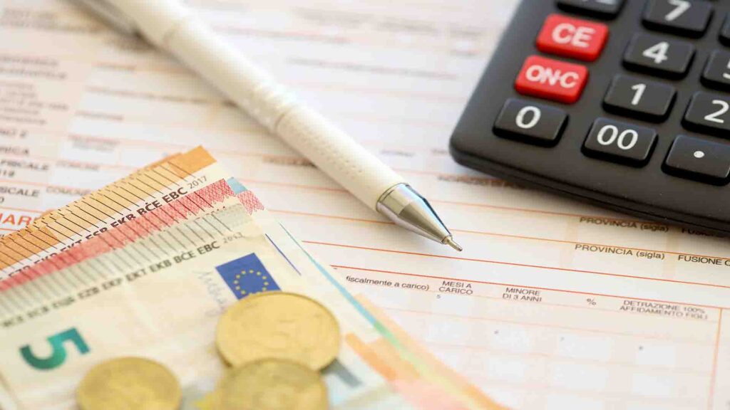Close-up of filling out a Portuguese tax form with a pen, calculator, and euro banknotes