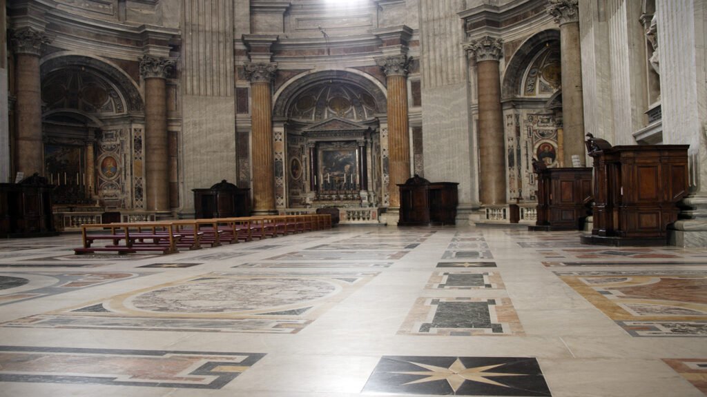 Interior view of Saint Peter’s Basilica in Vatican City, featuring grand columns, ornate altars, and Renaissance architecture