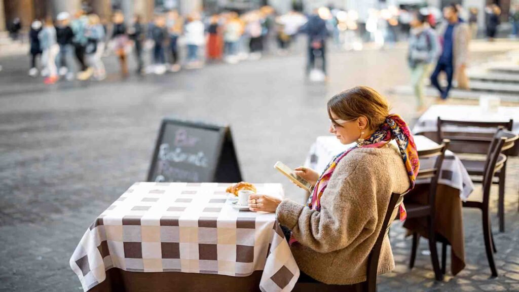 Woman sitting at an outdoor café near the Pantheon in Rome, enjoying Italian street life and historic surroundings