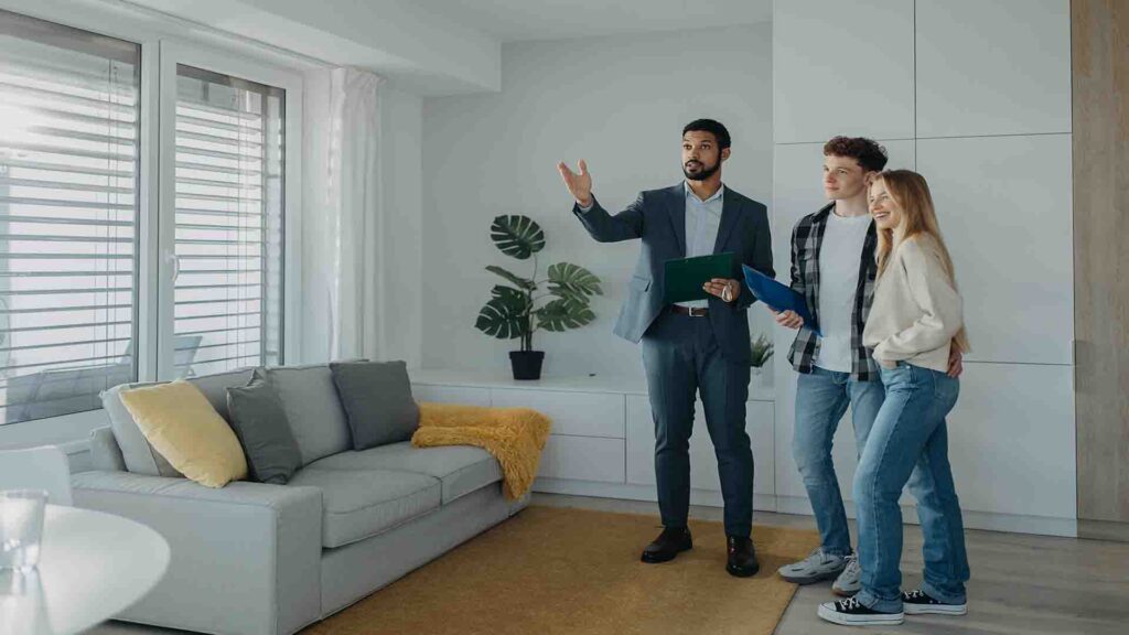 Happy young couple meeting a real estate agent while buying their new home in an apartment