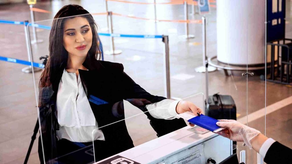 Passenger handing travel documents to airport staff at the check-in counter