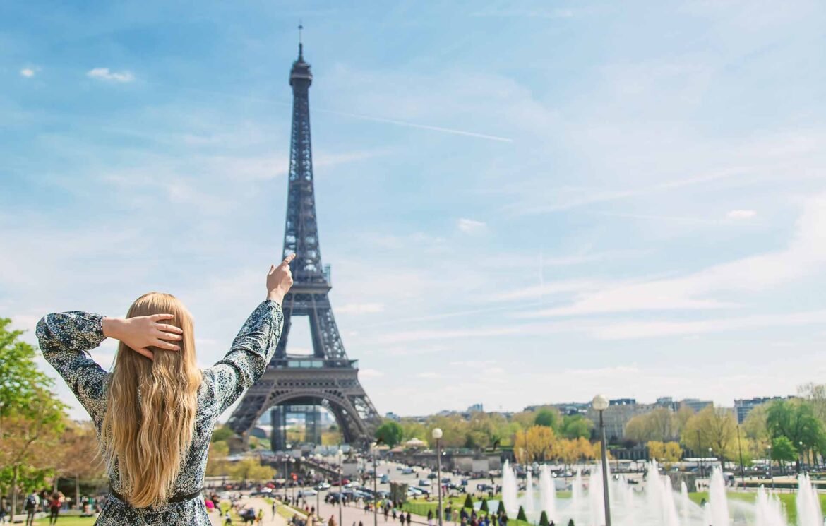 Paris visa requirements concept image showing a woman near the Eiffel Tower in Paris