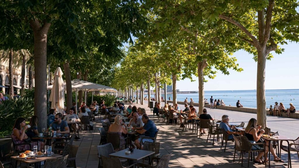 People enjoying breakfast and coffee at outdoor seaside cafés along the promenade in Barcelona’s Poblenou neighborhood