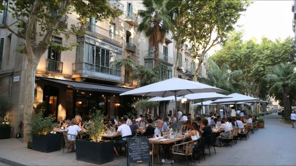 Locals dining outdoors at a modern café terrace in Barcelona’s Sant Antoni neighborhood