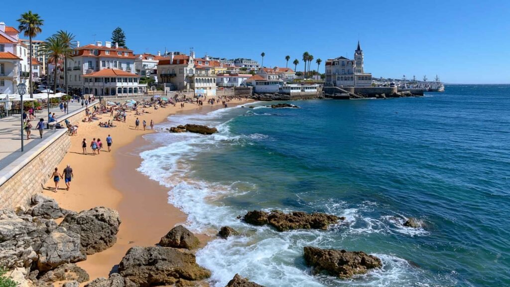 Visitors enjoying Cascais Beach near Lisbon with sandy shoreline, Atlantic waves, and a scenic waterfront promenade