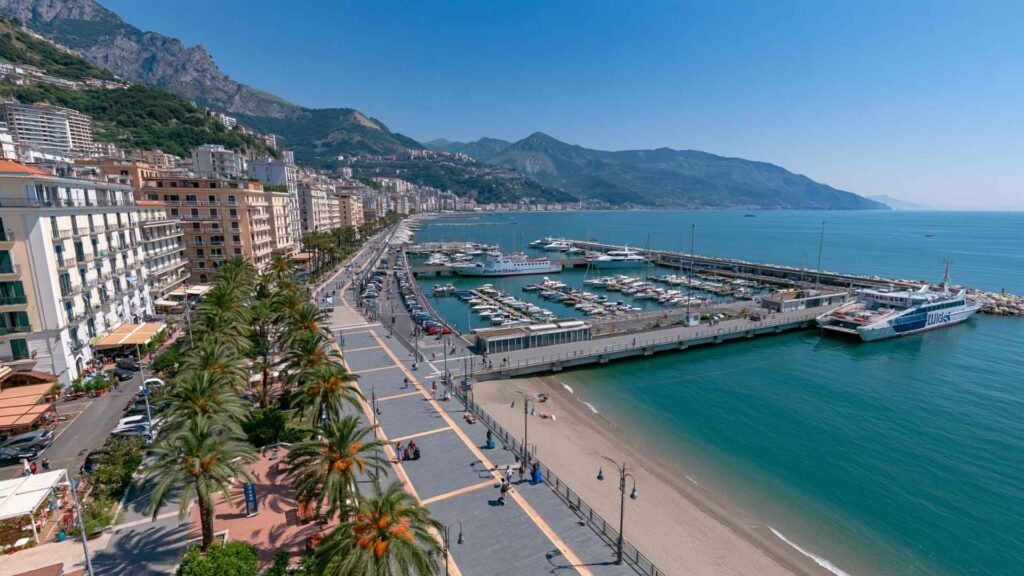 Panoramic view of Salerno waterfront featuring the marina, ferry terminal, palm-lined promenade and hotels, a practical base for exploring the Amalfi Coast.
