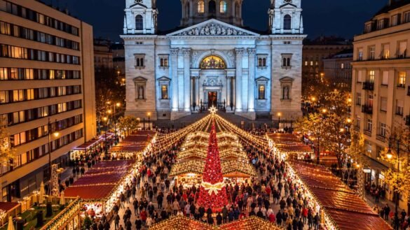 Christmas in Budapest with illuminated market stalls and a red Christmas tree beneath St Stephen’s Basilica at night.