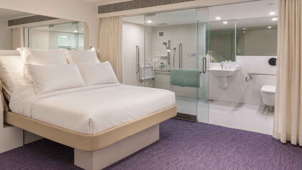 YOTELAIR Singapore Changi Airport Accessible Premium Queen cabin with an adjustable bed and glass-enclosed bathroom.